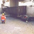 Officials examine cars crushed under total soft-story collapse after the Northridge earthquake.